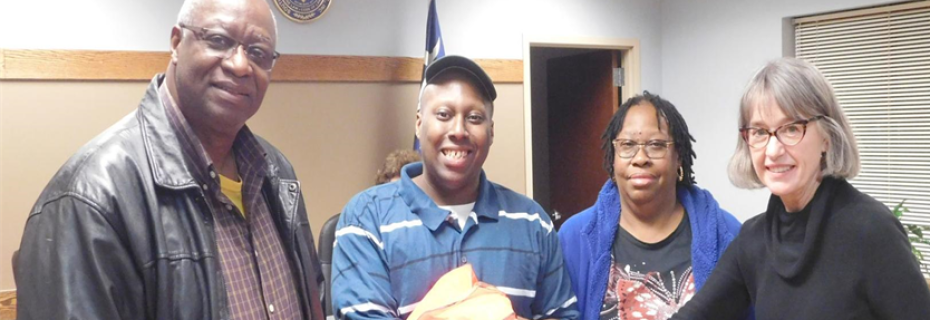 North Town Councilman Julius Jones, left, and Mayor Patty Carson, right, present North resident Marlon Milhouse, second from left, with a florescent safety vest for his volunteer work to clean up the town and help citizens move their trash cans to the curb on collection days. Milhouse’s mother, Ruby Milhouse, is also pictured.